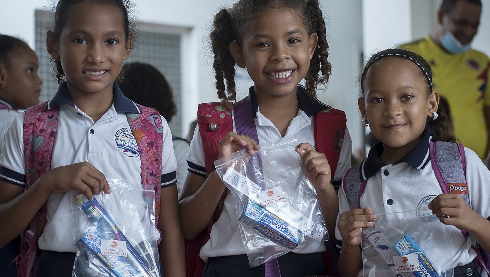 María Belén Montesino, Lucero Muñoz y Faber Torres recibiendo kits orales durante la jornada integral de salud en Manzanillo del Mar.